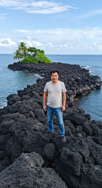 An Asian man standing on a rocky island #2