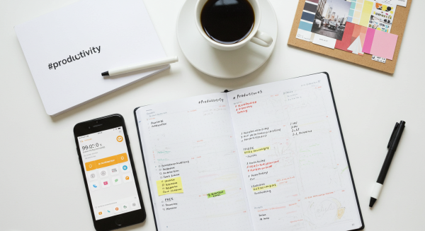 Flat lay of phone, planner, coffee, and mood board on white workspace #2
