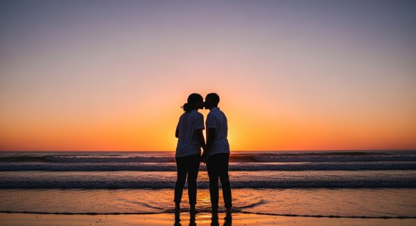 A shot of a young black man and woman kissing at the beach at dusk #2