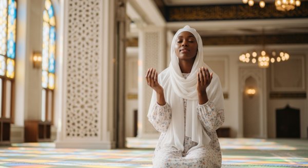 A black Muslim lady with a white hijab praying #3