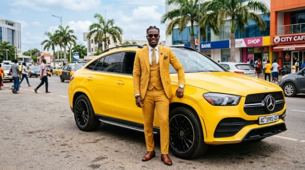 A young Black African man in a yellow suit standing by his yellow SUV